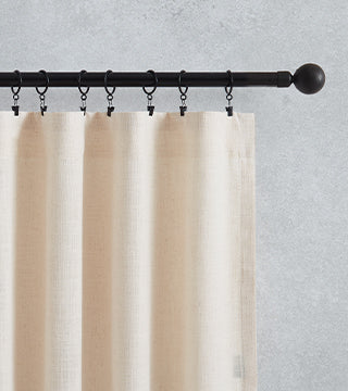 flat panel curtains hang on black rod with rings and clips